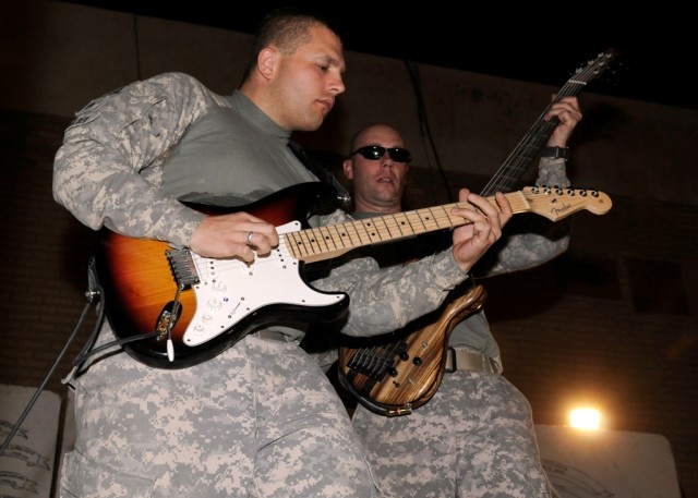 MAHMUDIYAH, Iraq - Guitarist Sgt. Jason Smelser (left), of Killeen, Texas, and bassist Staff Sgt. Dennis Milne, of Rockford, Ill., with the 1st Calvary Division Army Rock Band, jam at Forward Operating Base Mahmudiyah June 23. The band, known as G.O....