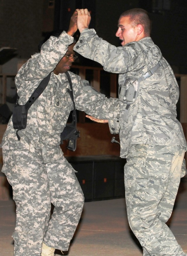 MAHMUDIYAH, Iraq - Sgt. 1st Class Mary Dangerfield (left), of Broadway, N.C., and Senior Airman Greg Jones, of Columbus, Miss., with the 732nd Expeditionary Security Force Squadron, Detachment 2, dance together during a concert put on by the 1st Calv...