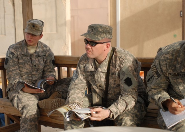 CAMP TAJI, Iraq - Spc. Lesley Schneider (at left) and Sgt. Philip Amos, both of Erie, Pa., with Headquarters and Headquarters Company, 1st Battalion, 112th Infantry, 56th Stryker Brigade Combat Team, trade hunting stories and read copies of Ducks Unl...