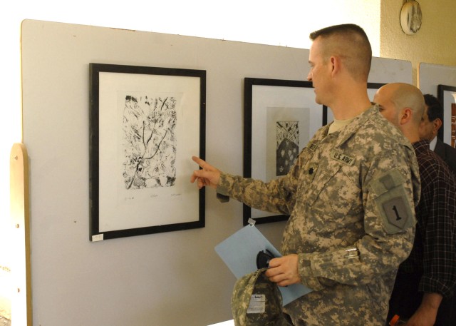 BAGHDAD - Lt. Col Christopher Beckert, a native of Madison, Conn., deputy commander, 2nd Heavy Brigade Combat Team, 1st Infantry Division, Multi-National Division - Baghdad looks at works of art created by students of the Baghdad School of Arts...