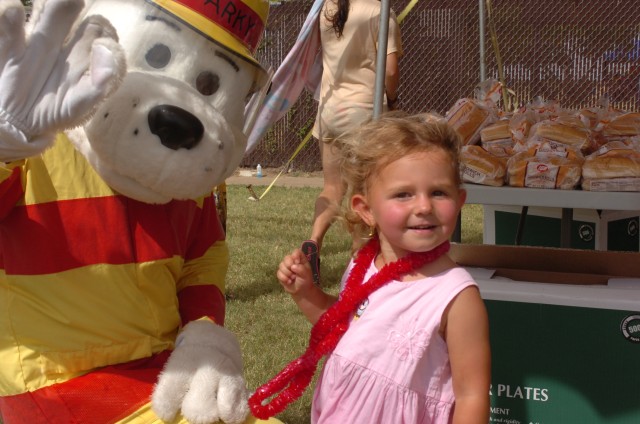 Sparky the fire dog and 3-year-old Celine Johnson, of Copperas Cove, Texas, daughter of Sgt. Grey Johnson, 3rd Battalion, 227th Aviation Regiment, 1st Cavalry Division, strike a pose safety during 1st ACB, 1st Cav. Div.'s Stand-down Safety Day June 1...