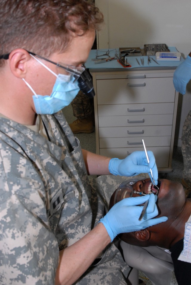 BAGHDAD - Capt. George Hoggan, a dentist with the 464th Medical Company (DS), 421st Multifunctional Medical Battalion, 44th Medical Command, Multi-National Division-Baghdad, works to build up a Soldier's dental core in preparation for a crown at Camp...