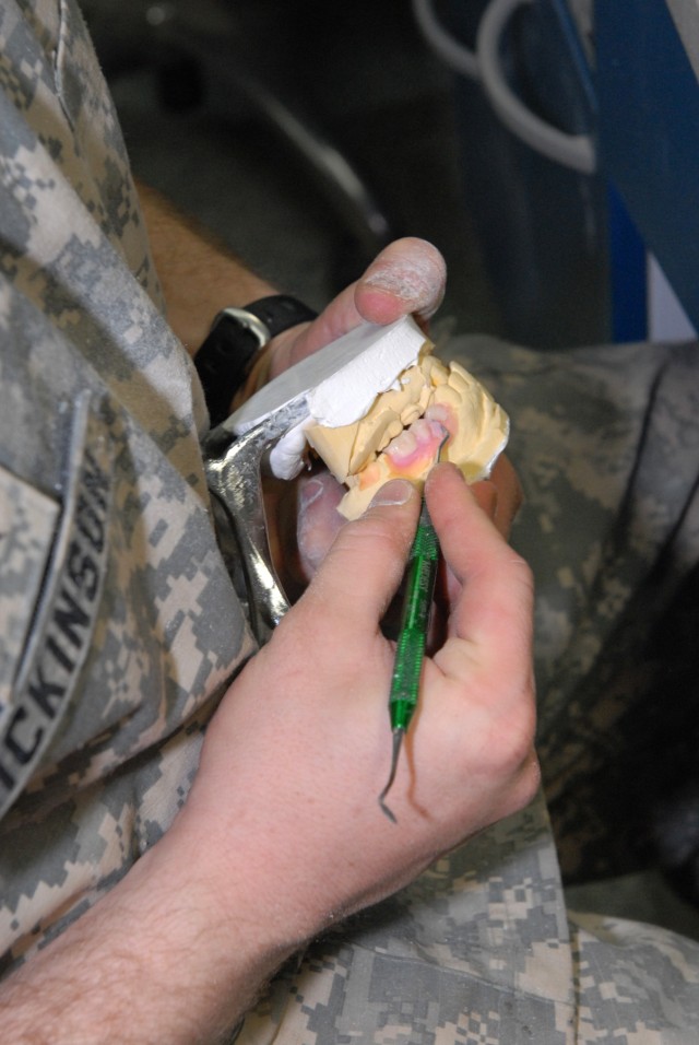 BAGHDAD - Using a dental scraping tool, Sgt. David Dickinson, a native of Salt Lake City, assigned to the 464th Medical Company (DS), 421st Multifunctional Medical Battalion, 44th Medical Command, Multi-National Division-Baghdad, makes sure that the ...