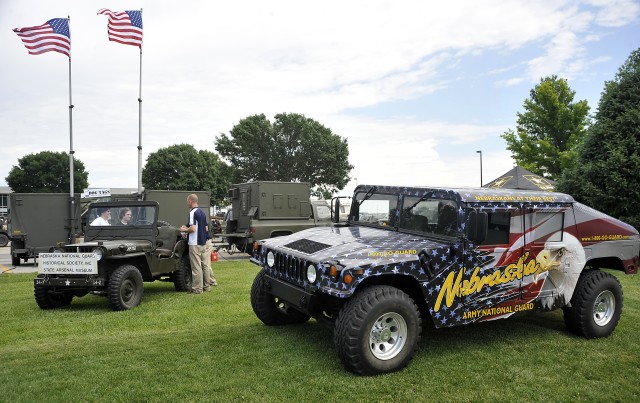 A Nebraska Army National Guard recruiter talks with a pair of visitors to the Gretna Middle School Parking lot, June 24, as the Military Vehicle Preservation Association makes a stop in Gretna, Neb. The MVPA is retracing the route of the U.S....