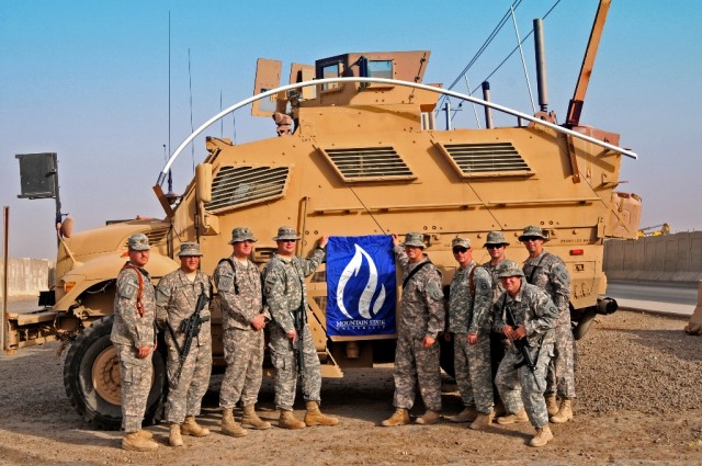 BAGHDAD - Mountain State University students and alumni deployed to Iraq with 150th Armored Reconnaissance Squadron hold the school's banner to show their appreciation for the university's raising of more than $8,700 for the squadron's family...
