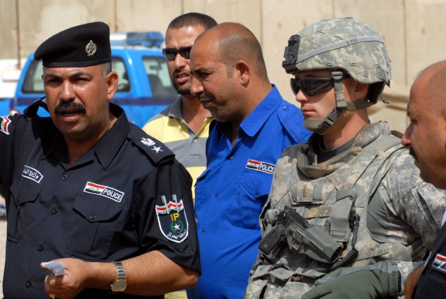 BAGHDAD -Second Lt. Sebastian Balint (right), first platoon leader, from Las Vegas, assigned to the 463rd Military Police Company, 93rd Military Police Battalion, 8th Military Police Brigade, observes as Lt. Col. Abbas (left) speaks with the Iraqi...