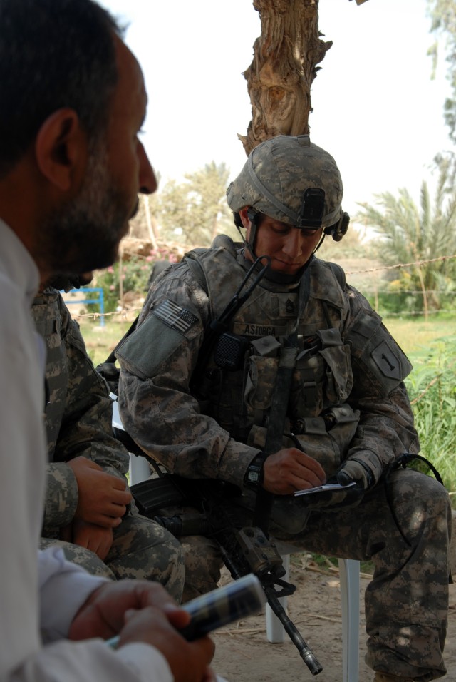 BAGHDAD - Sgt. 1st Class Sesilio Astorga, a platoon sergeant assigned to Company A, 1st Combined Arms Battalion, 63rd Armored Regiment, 2nd Brigade Combat Team, 1st Infantry Division, takes down notes while discussing security and infrastructure...