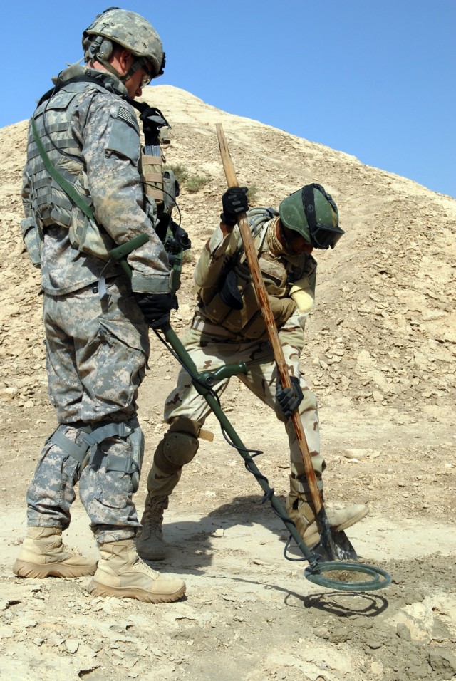 BAGHDAD - After Pfc. Daniel Parker's metal detector alerted to a buried metallic object, an Iraqi soldier from the 3rd Company, 4th Battalion, 24th Brigade, 6th Iraqi Army Division, used a shovel to dig up the object. Parker, a native of Jacksonville...