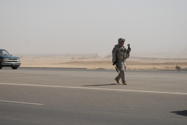 FALLUJAH, Iraq – Staff Sgt. Theodore Montgomery, a squad leader in B Company, 2nd Battalion 142nd Infantry, 56th Infantry Brigade Combat Team, directs traffic during recovery operations after a vehicle breakdown on the outskirts of Fallujah, June 24....