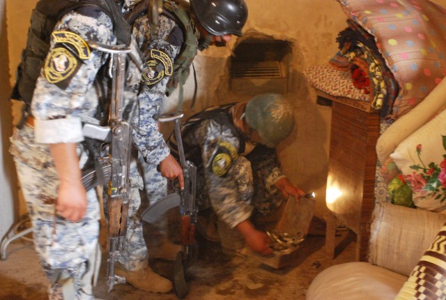 MA'DAIN REGION, Iraq - National Police officers assigned to the 3rd NP Brigade, 1st NP Division search for any suspicious inside of a home in a small village during "Operation Winged Lion II", June 26, in the Ma'dain region, located outside of easter...