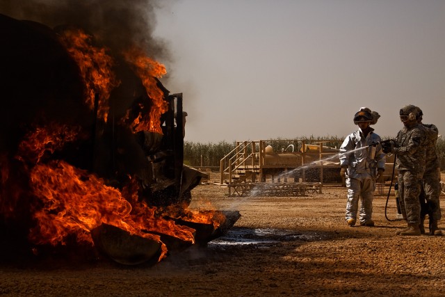TAJI, Iraq - Under the supervision of Ron Bailey, the fire prevention officer for Fire Department 1, Camp Taji, Iraq, Spc. Jose Ontiveros, from Covina, Calif., an aircraft mechanic in Company B, 615th Aviation Support Battalion, 1st Air Cavalry...