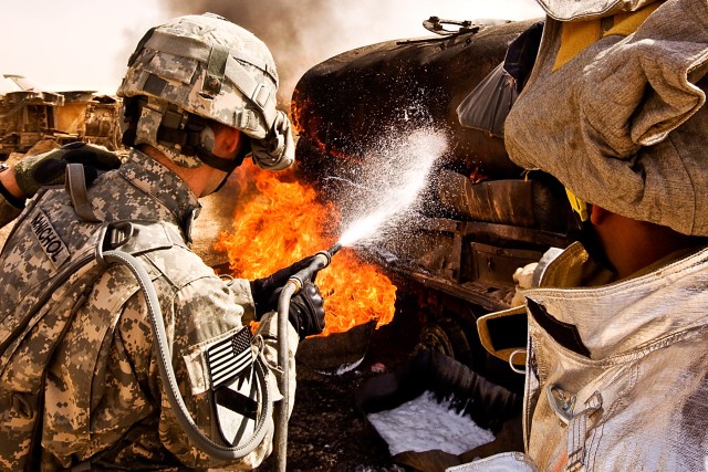 TAJI, Iraq - Using a new foam fire repellent, Staff Sgt. Jeremy McNichol from Lockeford (left), Calif., a downed aircraft noncommissionofficer in charge in 615th Avaition Support Battalion, 1st Air Cavalry Brigade, 1st Cavalry Division,...
