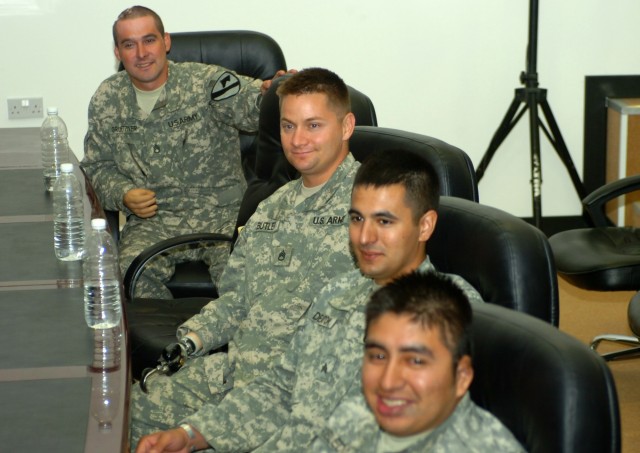 BAGHDAD - After a joke is told, four Soldiers from the Operation Proper Exit pilot program share a light-hearted moment while listening to a Multi-National Division-Baghdad operations brief June 27 at Camp Liberty, Iraq. During the brief, the visitin...
