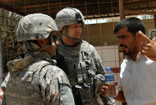 BAGHDAD - Maj. Christopher Ott, of Fort Riley, Kan., and executive officer of the 1st Combined Arms Battalion, 63rd Armored Regiment, 2nd Brigade, 1st Infantry Division, pays close attention to conrtractor, Ahmed Husain Saood as he tells them...