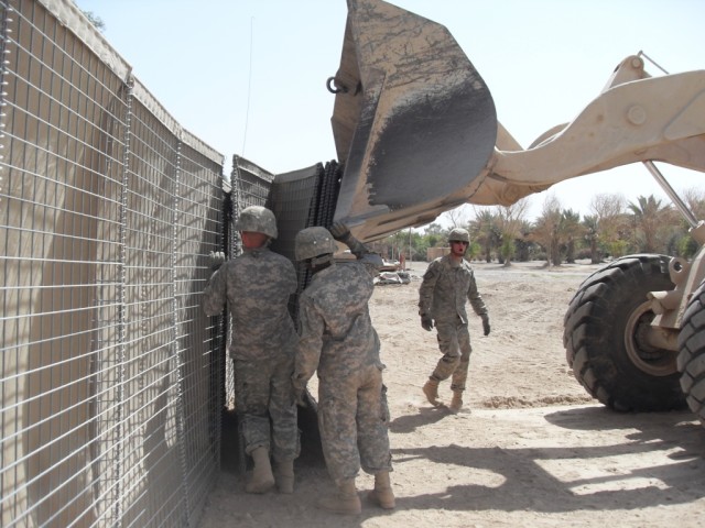BAGHDAD - Pfc. Christopher Zimla, heavy equipment operator, 46th Engineer Combat Battalion (Heavy), 225th Engineer Brigade, a native of Shelton, Conn. and Pfc. Dorian Bush, heavy equipment operator, from St. Anthony, Minn., position heavy seven foot ...