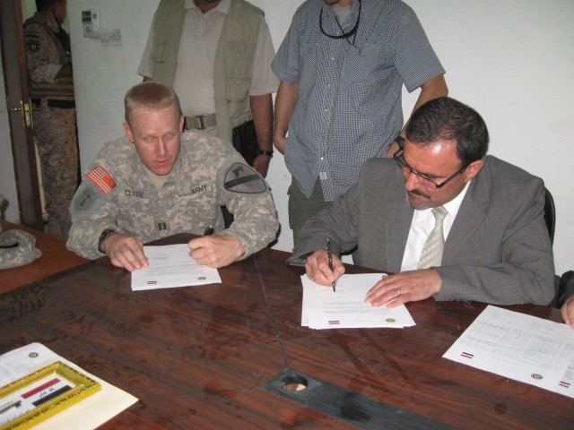 BAGHDAD - Harker Heights, Texas native Capt. Christopher Clyde (left), commander for Company C, 2nd  "Lancer" Battalion, 5th Cavalry Regiment, attached to the 1st Brigade Combat Team, 1st Cavalry Division, signs the record of return of Joint...