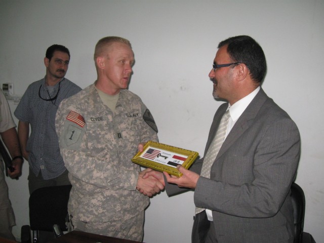 BAGHDAD - Harker Heights, Texas native, Capt. Christopher Clyde (left), commander for Company C, 2nd "Lancer" Battalion, 5th Cavalry Regiment, attached to the 1st Brigade Combat Team, 1st Cavalry Division, presents the key to Joint Security...
