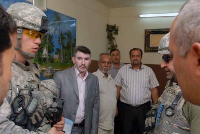 BAGHDAD - 1st Lt. Justin Casey, from Ogdensburg, N.Y., assigned to the Joint Projects Management Office, 2nd Brigade Combat Team, 1st Infantry Division, meets with representatives from the Ministry of Electricity at a graduation ceremony in the Nasir...