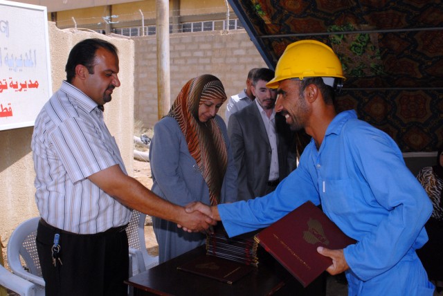 BAGHDAD - A former Son of Iraq receives his diploma for completing the electrical line refurbishment course during a graduation ceremony in the Nasir Wa Salam area here, June 25. The program is designed to give former Sons of Iraq the opportunity...