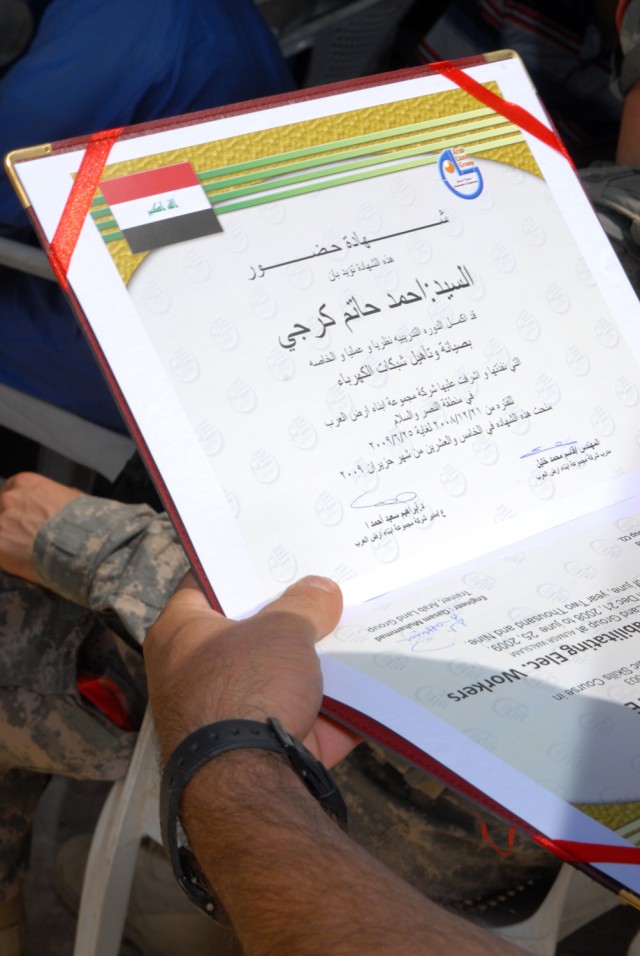 BAGHDAD - The diploma that a former Son of Iraq holds signifies the completion of the electrical line refurbishment course in the Nasir Wa Salam district here, June 25. Thirty students, all former Sons of Iraq, graduated the course and will now be an...