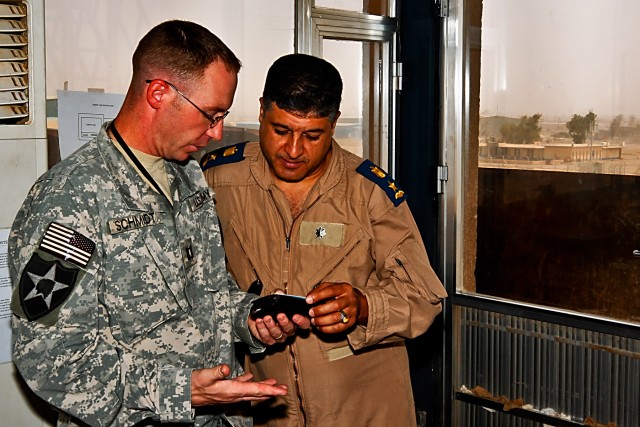 TAJI, Iraq - Capt. Stephen Schmidt (left), a UH-60 Black Hawk helicopter pilot and commander of Company F, 2nd Battalion, 1st Air Cavalry Brigade, 1st Cavalry Division, Multi-National Division - Baghdad, explains the credentials necessary   for Lt. C...