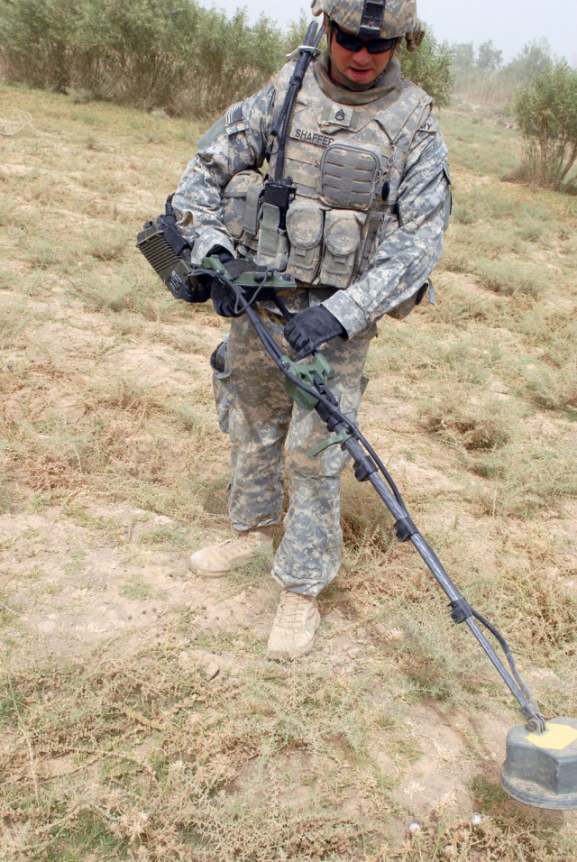 A Troop, 1st Battalion, 150th Armor Reconnaissance Squadron, 30th Heavy Brigade Combat Team, sweeps for weapon caches in the village of Arab Jasim here, July 3. Shaffer and his team swept through the village, along with Iraqi Army Soldiers of 1st Com...