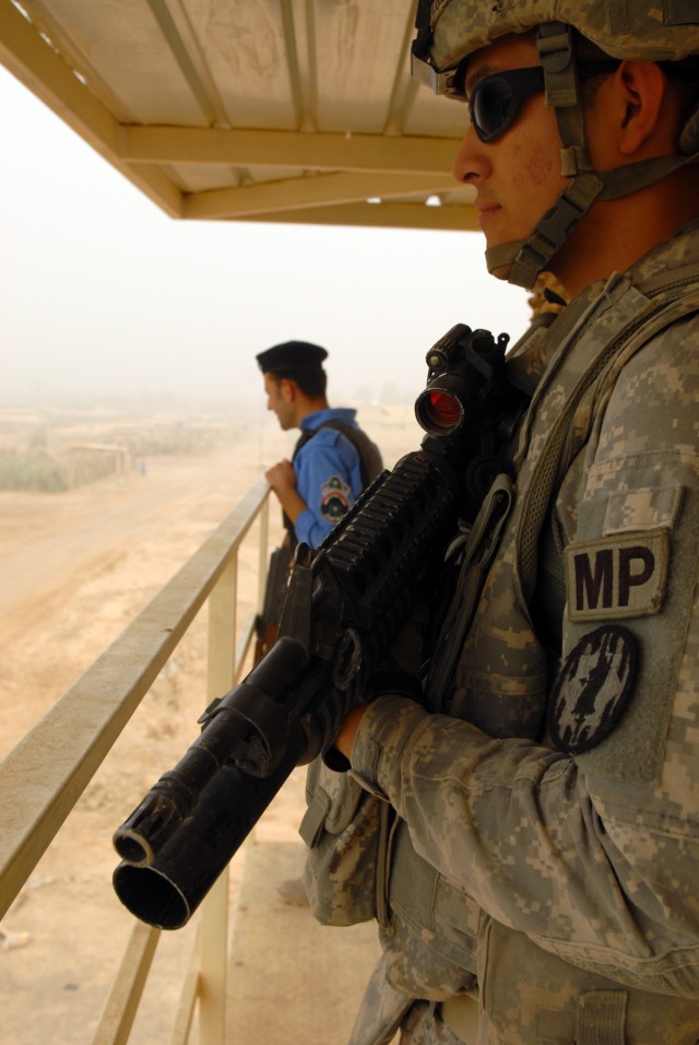 BAGHDAD - Spc. Jovanny Lovato, a military policeman from Stockon, Calif., pulls security from a guard tower with an Iraqi Policeman at the new Tarmiyah Iraqi Police Station, here, July 3. Lovato is assigned to the 591st Military Police Company,...