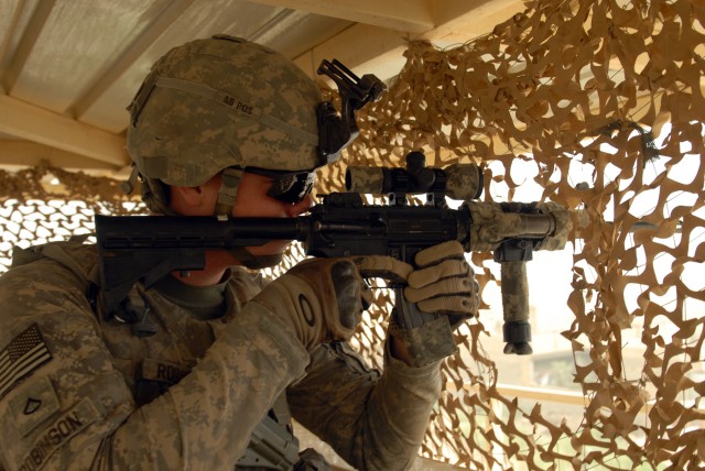 BAGHDAD - Pfc. Jordan Robinson, a military policeman from Salisbury, Md., pulls security from a guard tower at the new Tarmiyah Police Station, here, July 3. Robinson is assigned to the 591st Military Police Company, 93rd Military Police...