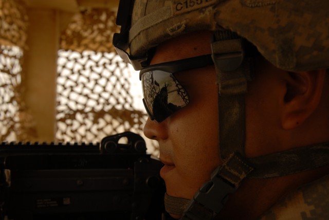 BAGHDAD - Pfc. Samuel Castaneda, a military policeman from El Paso, Texas, pulls security from a tower at the new Tarmiyah Police Station here, July 3. "You can see farther, your visibility is greater," Castaneda said of the tower's elevated...