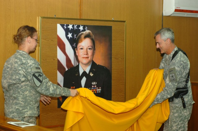 BAGHDAD - U.S. Army Judge Advocate General, Lt. Gen. Scott C. Black (right), and Smithfield, N.C. native, Pfc. Roxanne Johnson, a paralegal specialist, 1st Cavalry Division, Multi-National Division-Baghdad, unveil a picture of Warwick, R.I. native, C...
