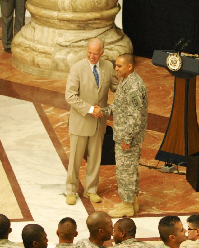 BAGHDAD - Spc. Benny Ares, 8th Military Police "Watchdog" Brigade Soldier, shakes hands with Vice President Joe Biden during the July 4 Naturalization Ceremony at Camp Liberty, Iraq.  Ares, a Dominican Republic native, joined 235 other service...