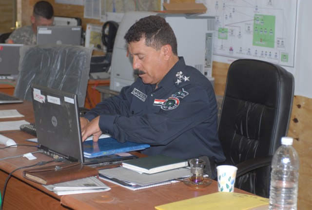 Brig. Gen. Mohammed Sala Abass, an Iraqi Police liaison officer, works at his desk inside 2nd Brigade, 1st Cavalry Division's headquarters, on Forward Operating Base Warrior, Kirkuk, Iraq, July 3. Abass, along with other liaisons, began working on FO...