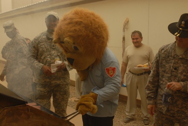 The Lion of Kirkuk tries his hand at grilling during a Fourth of July barbeque and celebration on Forward Operating Base Warrior, Kirkuk, Iraq. The lion is the official mascot of the Iraqi Police in the city, and joined the Soldiers and their Iraqi p...