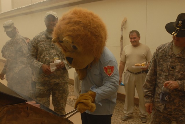 The Lion of Kirkuk tries his hand at grilling during a Fourth of July barbeque and celebration on Forward Operating Base Warrior, Kirkuk, Iraq. The lion is the official mascot of the Iraqi Police in the city, and joined the Soldiers and their...