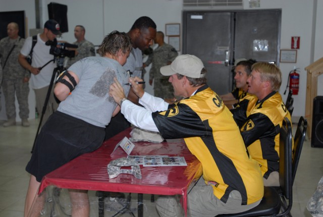 Former Pittsburgh Steelers' Coach Bill Cohwer signs the shirt of a lucky Soldier on Forward Operating Base Warrior, Kirkuk, Iraq, during a visit from the coaches July 2. Dozens of Soldiers and Airmen passed by the coaches' table receiving autographs ...