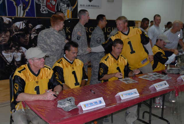 Pfc. Tad Letourneau, a St. Amant, La., native and a cook with Headquarters and Headquarters Company, 2nd Special Troops Battalion, 2nd Brigade Combat Team, 1st Cavalry Division, shakes hands with Baltimore Ravens' Coach John Harbaugh during a visit f...