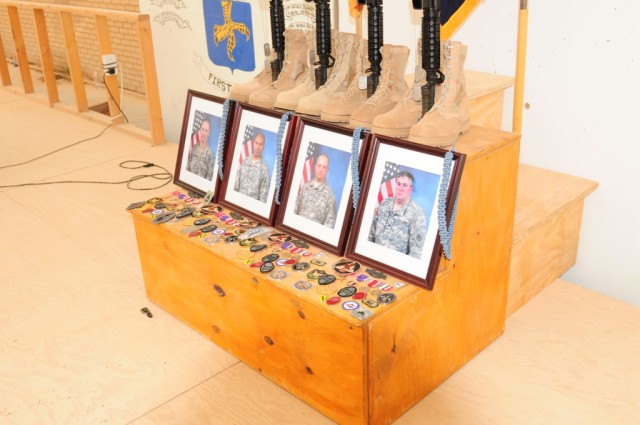 MAHMUDIYAH, Iraq - The traditional memorial of boots, rifle, helmet, and dog-tags stands in honor of Sgt. First Class Edward Kramer, Sgt. Juan Baldeosingh, Sgt. Roger Adams Jr. and Spc. Robert Bittiker, during a memorial service held in their honor a...