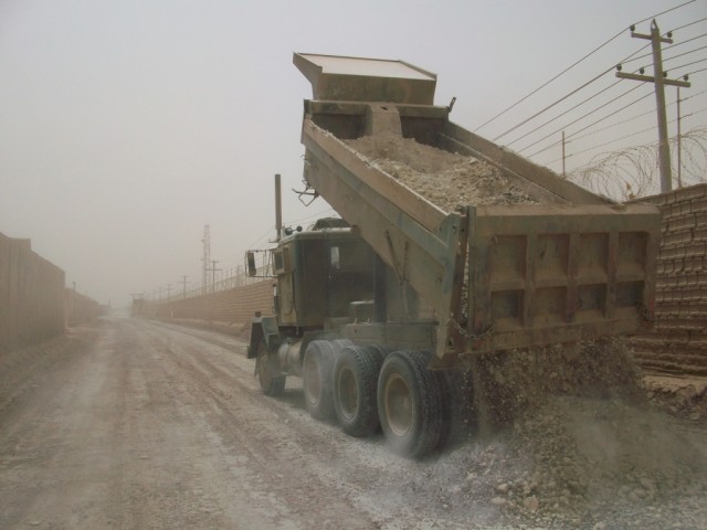 BAGHDAD - A 20-ton dump truck driver from the 277th Engineer Company, based in San Antonio, hauls gravel that will be emplaced on the road. The engineers have just completed road repairs to a vital road that connects Camps Liberty and Victory. ...