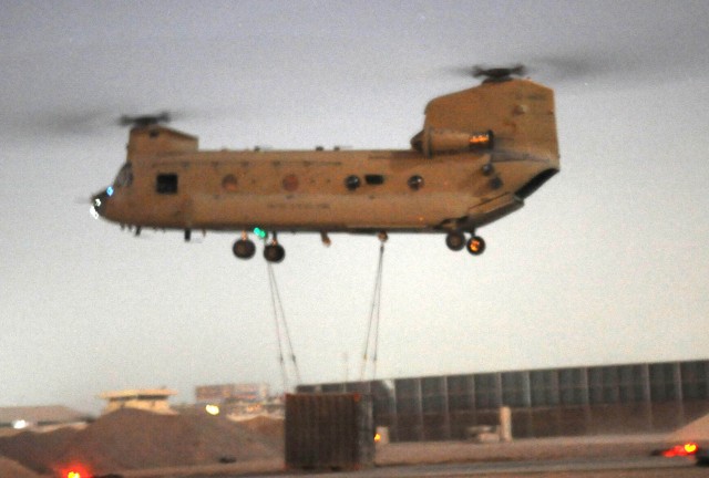 BAGHDAD - A CH-47 Chinook helicopter prepares to take off with a sling loaded container full with computer equipment during a night-time sling load operation July 8 at Joint Security Station Loyalty, Iraq, located in the 9 Nissan district of...