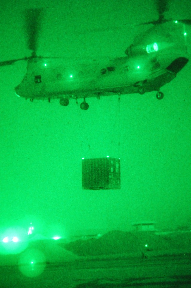 BAGHDAD - A CH-47 Chinook helicopter prepares to take off with a sling loaded container full with computer equipment during a night-time sling load operation July 8 at Joint Security Station Loyalty, Iraq, located in the 9 Nissan district of...