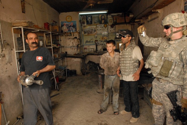 1st Lt. Daniel Braud, a Kingwood, Texas native and platoon leader in 4th Squadron, 9th Cavalry Regiment, 2nd Brigade Combat Team, 1st Cavalry Division, takes a photo of Salar Ghazi Fauzi showcasing his new impact socket wrench he purchased for his...