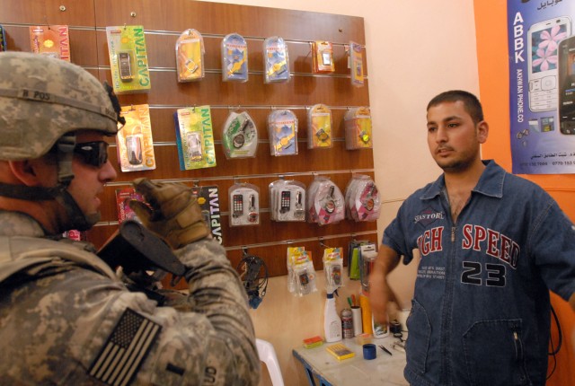 1st Lt. Daniel Braud, a Kingwood, Texas native, and platoon leader in 4th Squadron, 9th Cavalry Regiment, 2nd Brigade Combat Team, 1st Cavalry Division, checks on a cell phone store in Daquq, Iraq, July 7, which is owned by Ali Abbas Muhsin, who...