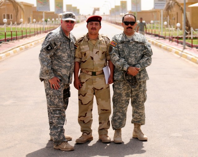 MAHMUDIYAH - Sgt. Waine Haley, of 30th Heavy Brigade Combat Team, (left) poses with Sgt. Saad Salim Khashan, of the 17th Iraqi Division and an interpreter known as "John," as an Iraqi public affairs student practiced camera techniques during a...