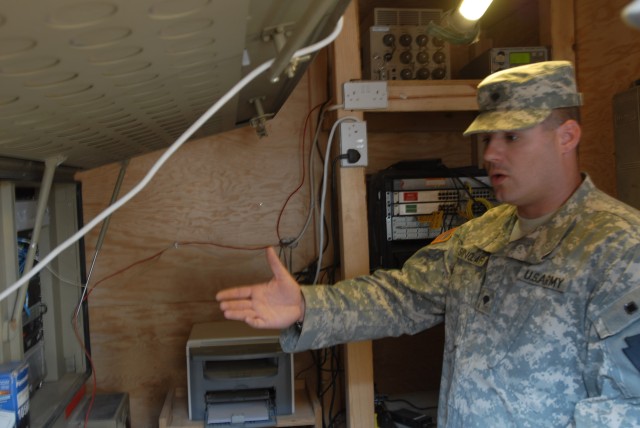 CAMP TAJI, Iraq - Spc. Robert Sinclair of Indiana, Pa., a satellite technician with 656th Signal Company, 56th Stryker Brigade Combat Team,explains the importance of a satellite transmission terminal July 10. The terminal enables Soldiers to make pho...