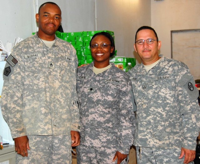 BAGHDAD - From left: Staff Sgt. Frederick Murray of Rose Hill, N.C.; Spc. Julia Clark, of Fayetteville, N.C.; and Spc. Mariano Rosa, of Medellin, Colombia, who make up the headquarters supply section of 30th Heavy Brigade Combat Team, pose for a phot...