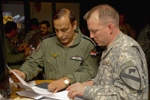 TAJI, Iraq- Brig. Gen. Nazim Liftah Al Agwadi (left), of the Iraqi air force, commander of Al-Taji Airfield, discusses notes with Col. Douglas Gabram, from Cleveland, Ohio, commander, 1st Air Cavalry Brigade, 1st Cavalry Division, Multi-National Divi...