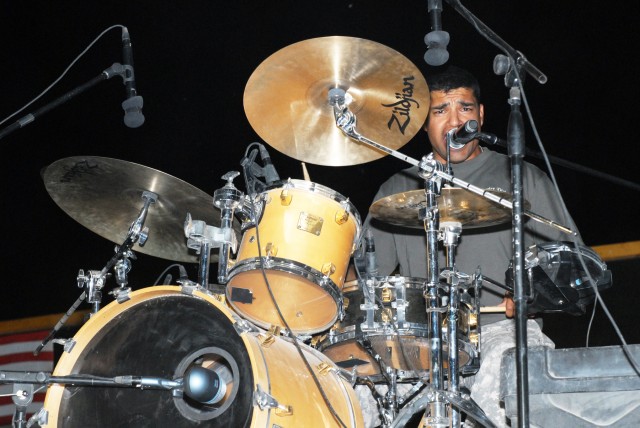 BAGHDAD - While banging on the drums, Staff Sgt. Rodolfo Rendon, a native of Uvalde, Texas, assigned to 1st Cavalry Division Band, Division Special Troops Battalion, 1st Cav. Div., sings a tune for the crowd at Camp Liberty, here, July 16. The...