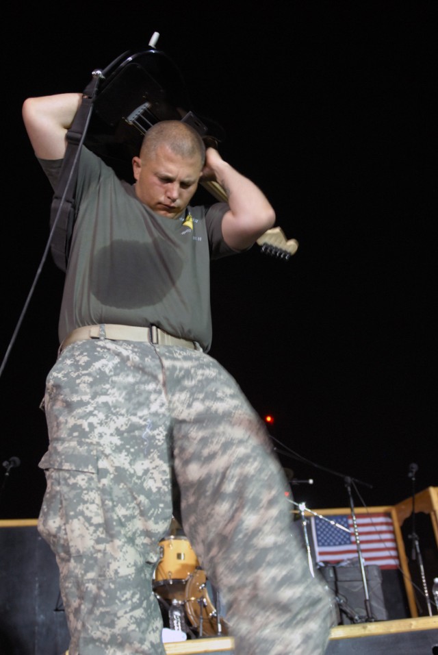 BAGHDAD - Killeen, Texas native, lead guitarist, Sgt. Jason Smelser, assigned to 1st Cavalry Division Band, Division Special Troops Battalion, 1st Cav. Div. does his signature move playing the last song of the night, "Free Bird" behind his head at...