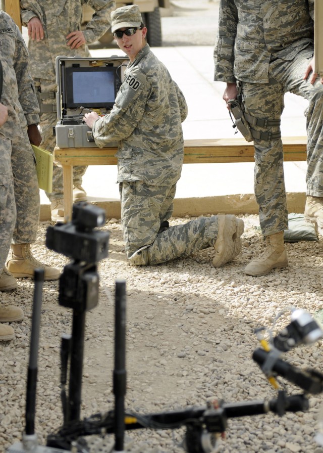 ZAIDAN, Iraq - Airman 1st Class Hans Metz with the 447th Explosive Ordnance Disposal team, demonstrates the remove-controlled robot used to help with disarming improvised explosive devices recently at Combat Outpost Meade. Metz, of Oak Dale, Minn. is...
