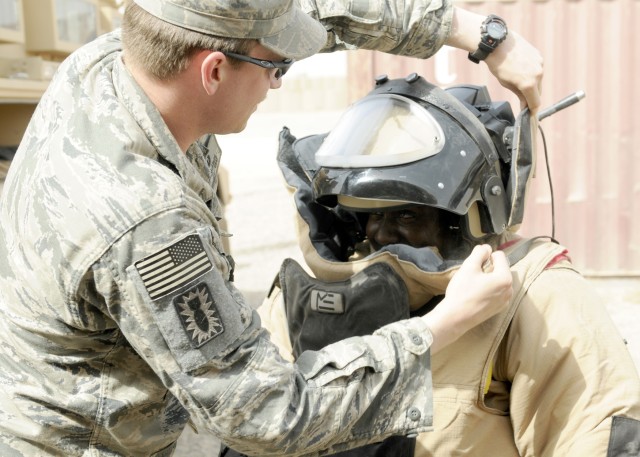 ZAIDAN, Iraq - Tech Sgt. Matthew Stark, with the 447th Explosive Ordnance Disposal team, (left) helps Sgt. Mica Joseph, with 1st Battalion, 113th Field Artillery Regiment, 30th Heavy Brigade Combat Team, put on the bomb suit worn by EOD when they...